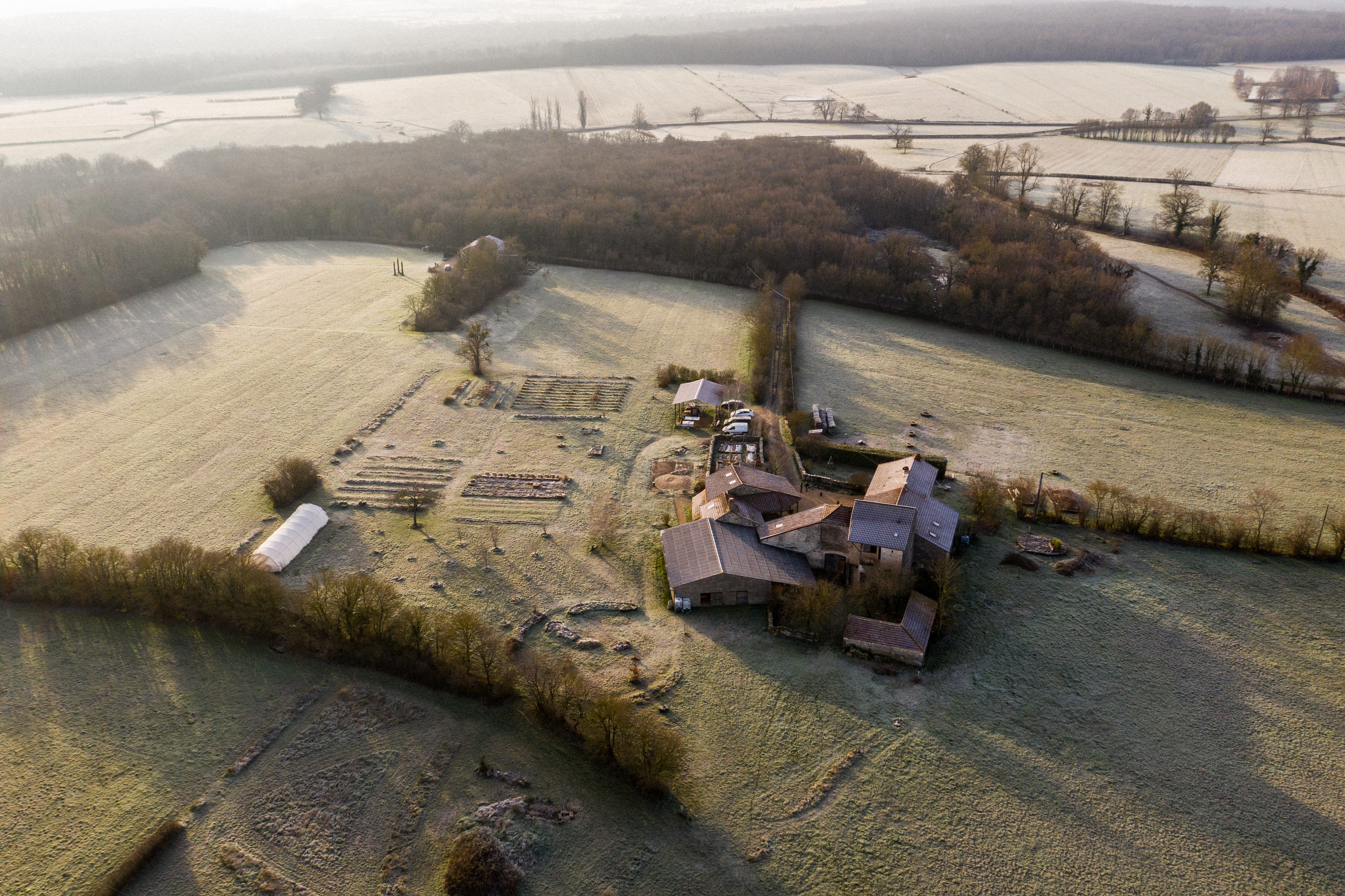 maison isolée à la campagne entourée de champs et de forêt