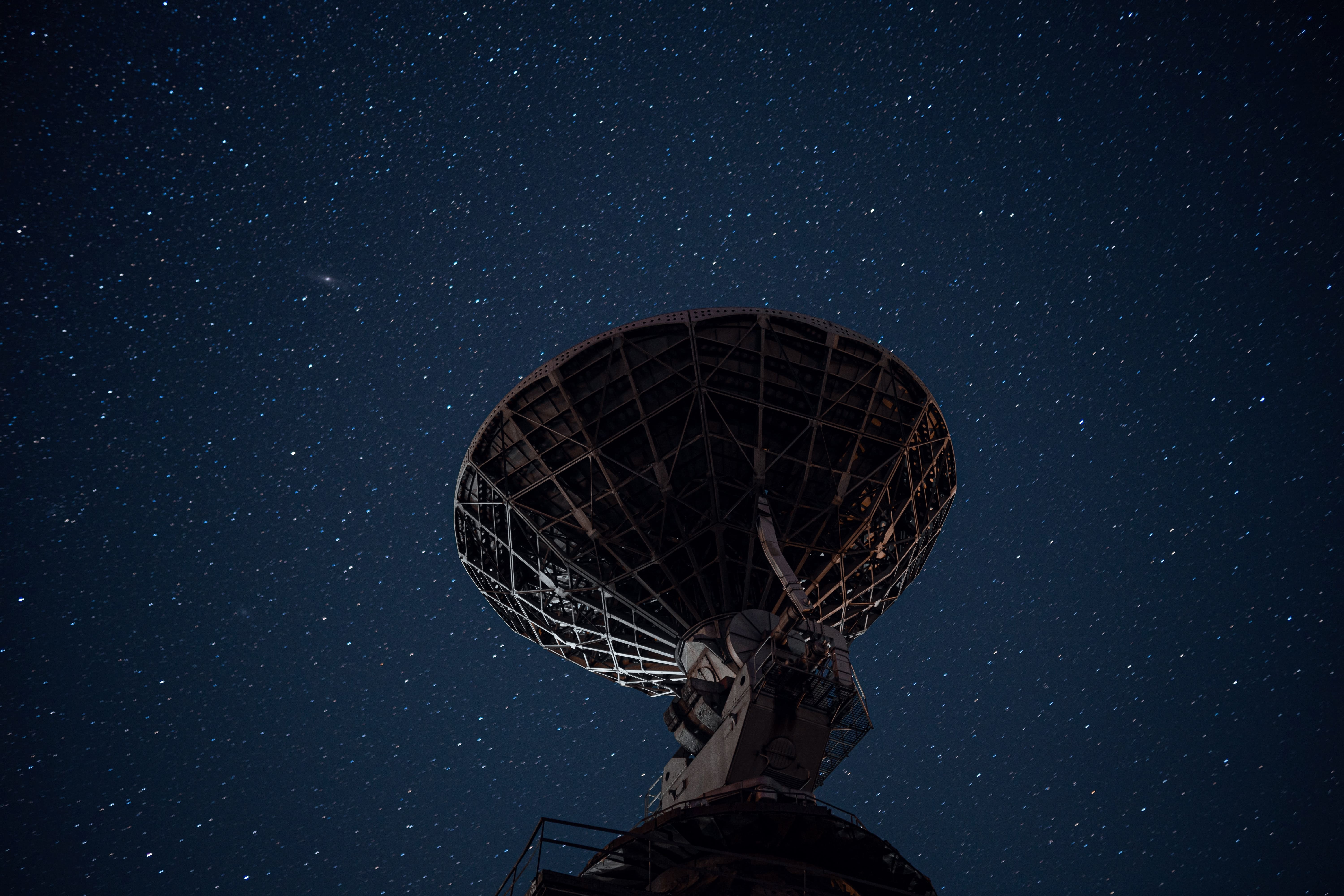 station de base terrestre d'un téléport en forme de parabole géante, pointée vers les étoiles